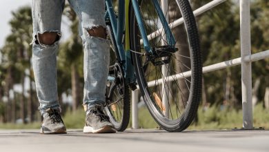 Homem caminhando ao lado de sua bicicleta